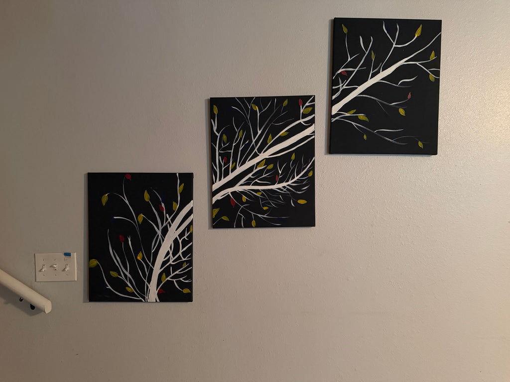 Set of three framed acrylic paintings featuring white branches with green and red leaves on black canvas, 14x20 each
